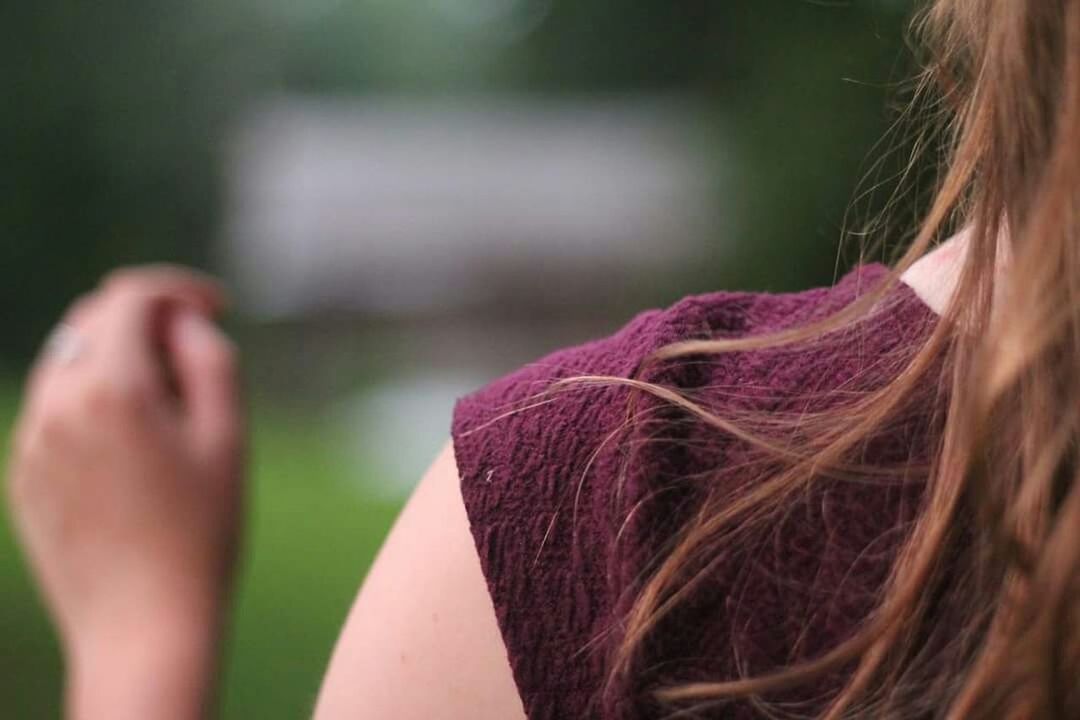 CLOSE-UP OF WOMAN HOLDING HAIR