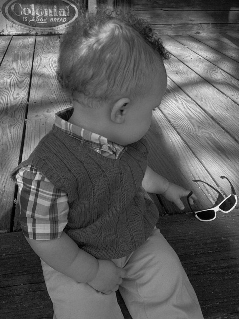 Boy on floorboard picking up sunglasses