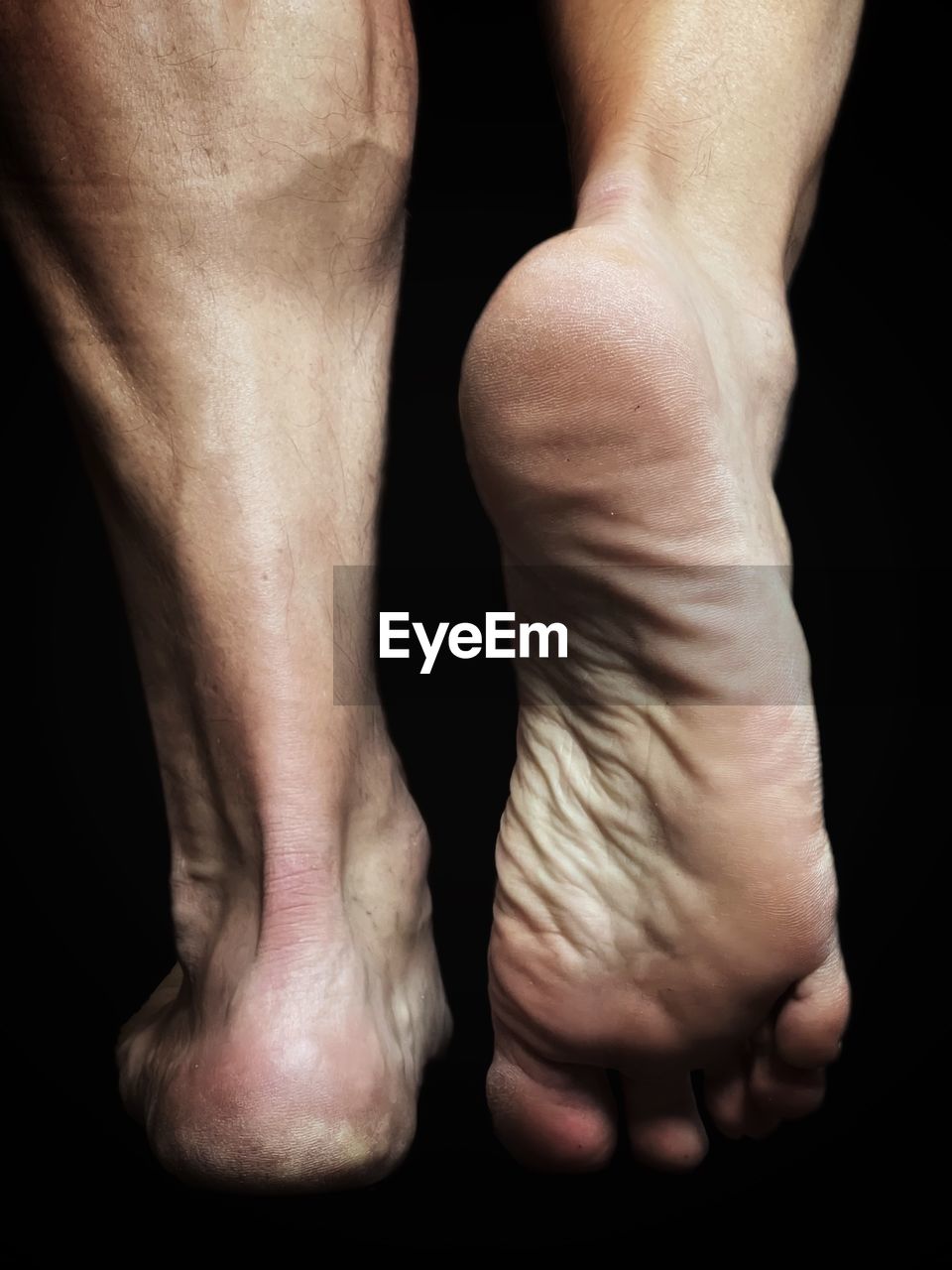 Close-up of human feet against black background