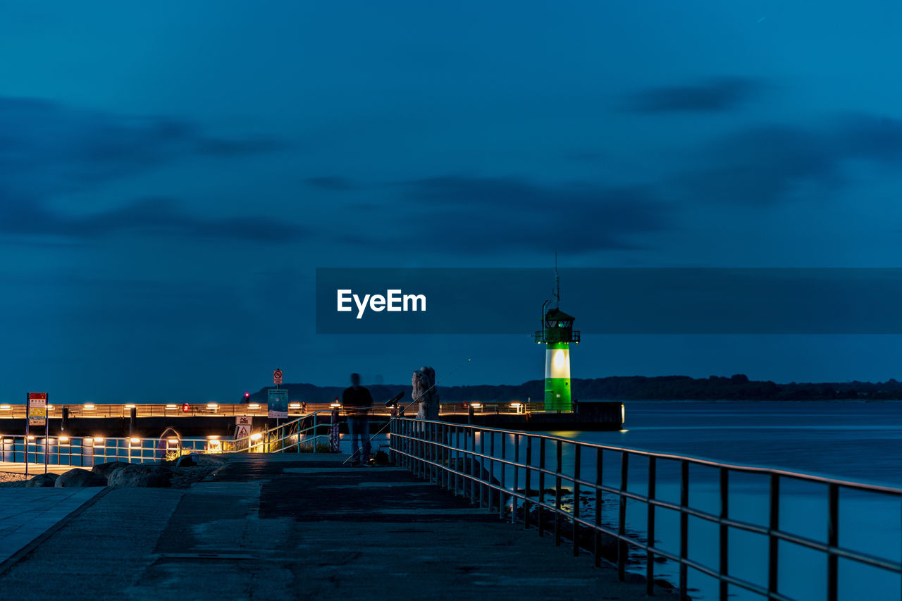 LIGHTHOUSE BY SEA AGAINST SKY AT NIGHT