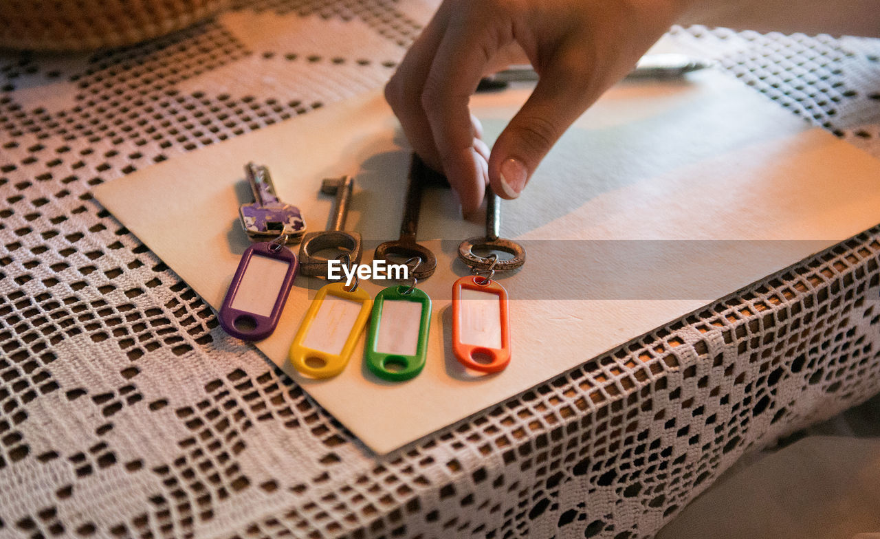 Cropped image of hand picking key on table