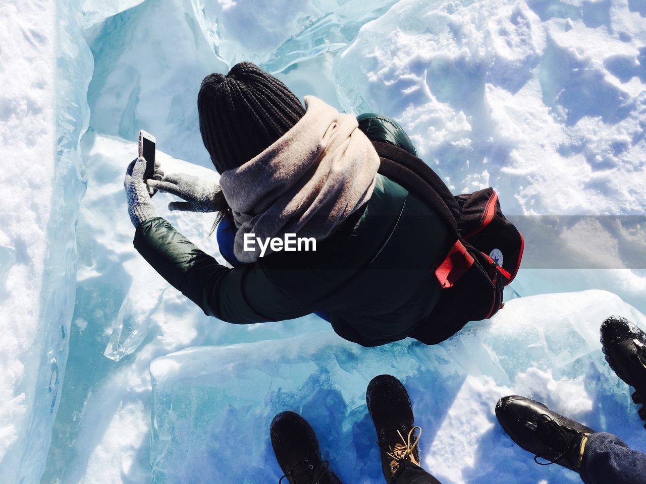 High angle view of person photographing while standing on snow covered field