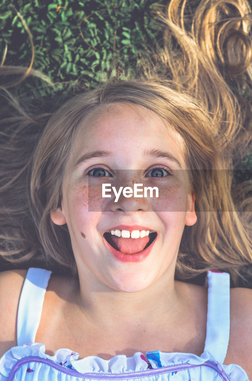 High angle portrait of girl lying down on field