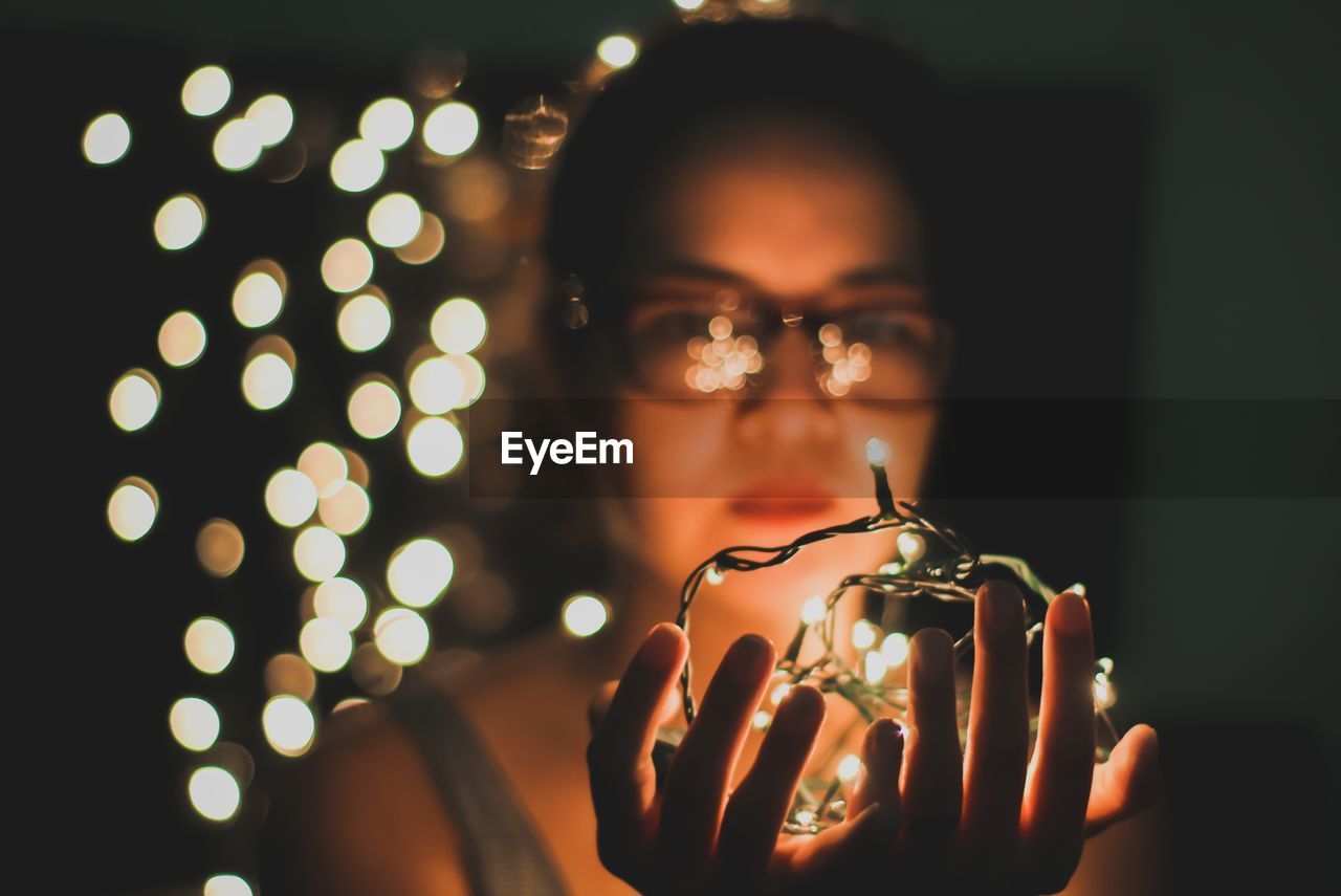 Close-up of woman holding illuminated lights