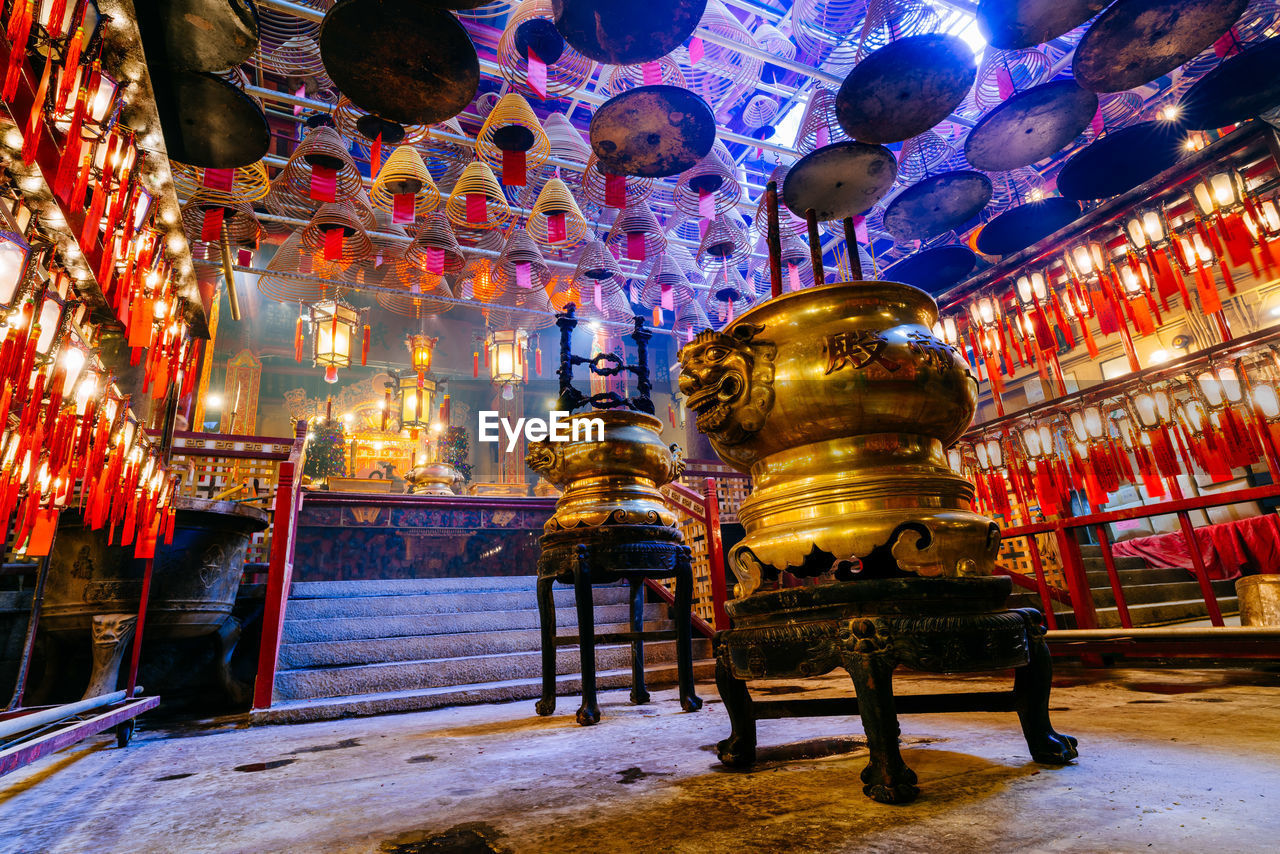 LOW ANGLE VIEW OF ILLUMINATED STATUE AGAINST TEMPLE