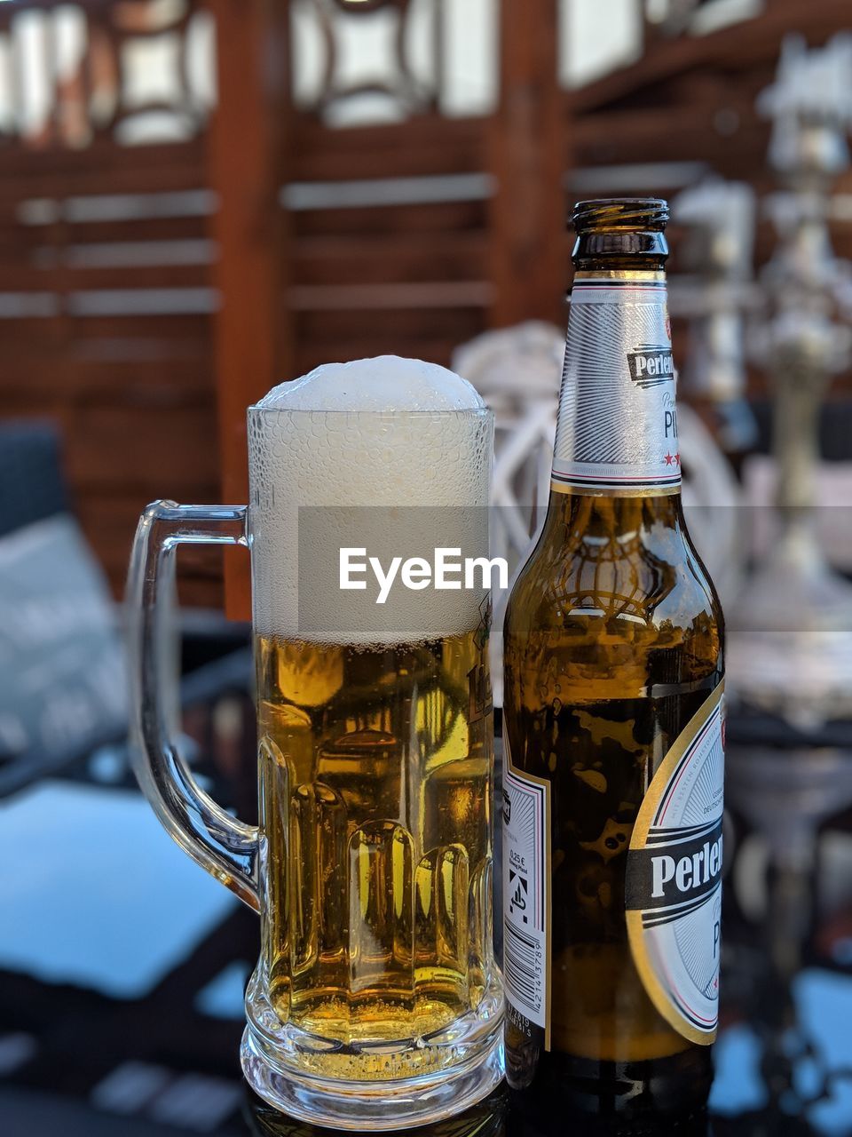 CLOSE-UP OF BEER GLASS WITH BOTTLE ON TABLE