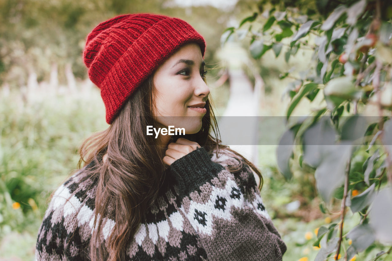 Woman in knit hat by plants