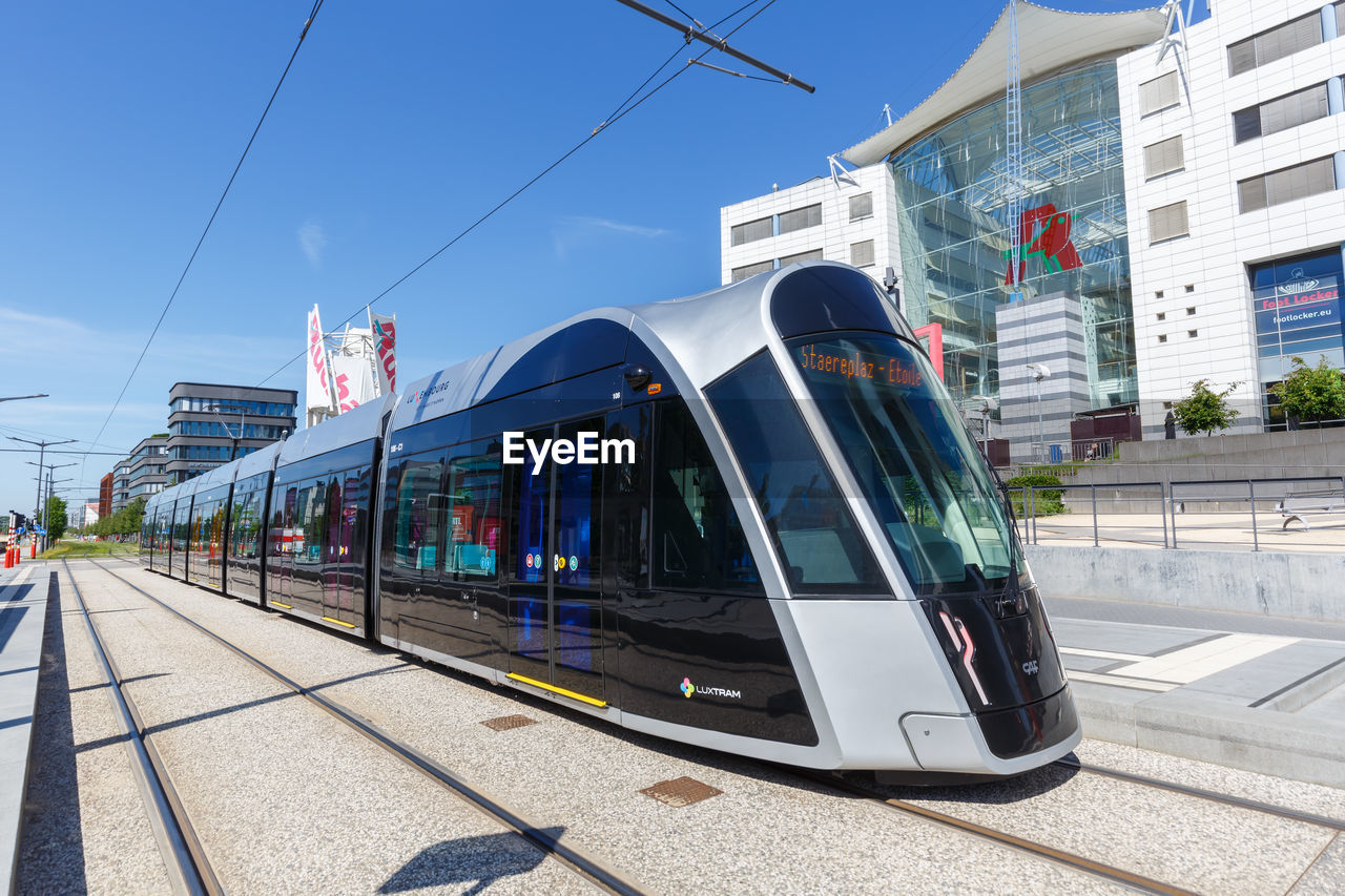 TRAIN AT RAILROAD STATION AGAINST SKY