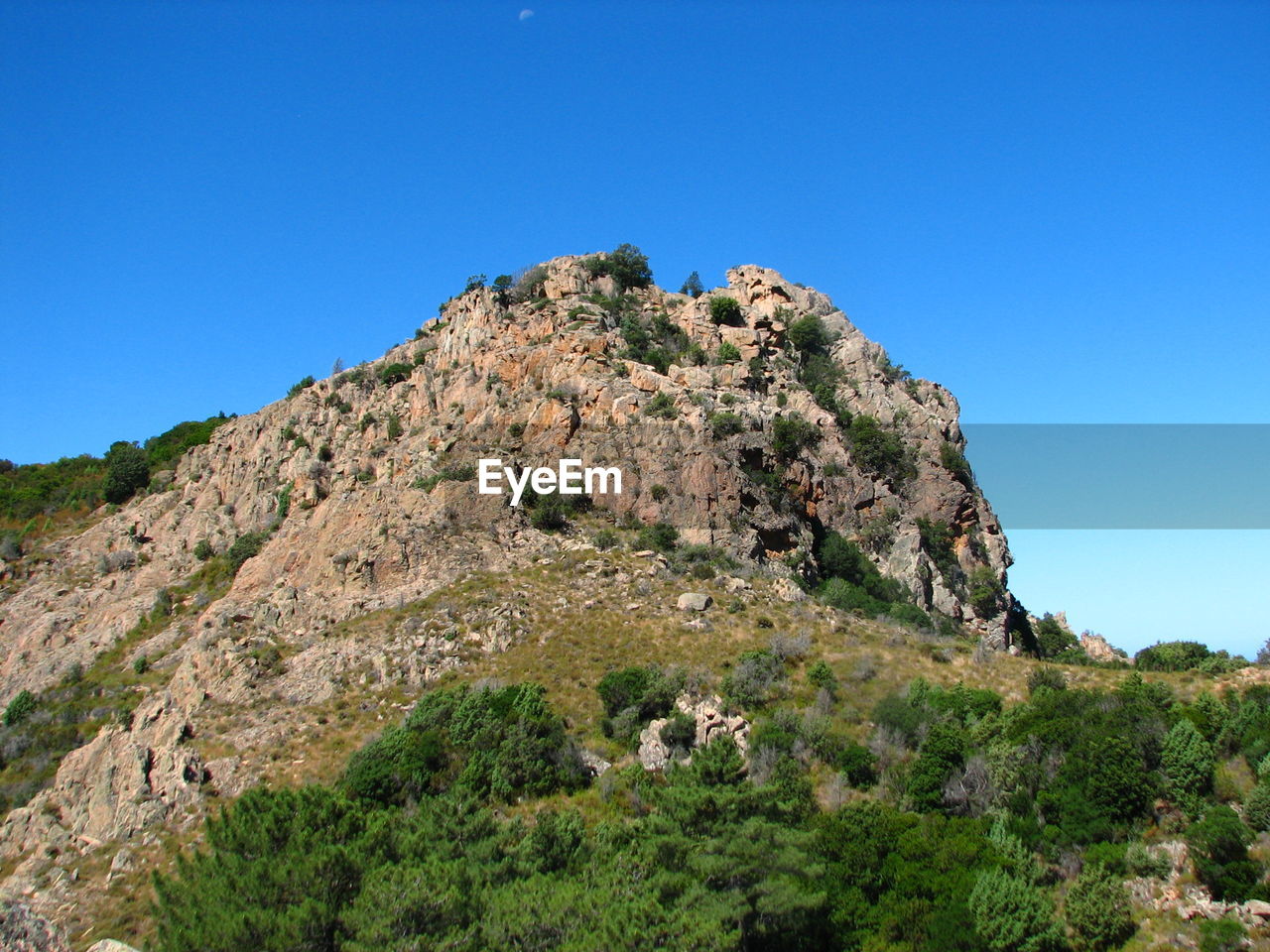 Low angle view of mountain against clear blue sky