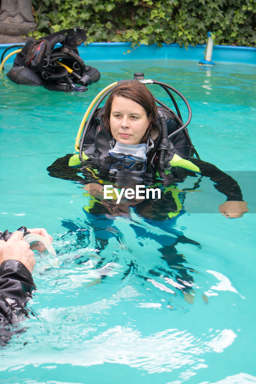Woman wearing diving equipment while swimming in pool
