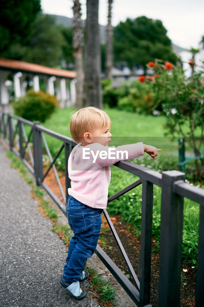 BOY STANDING BY RAILING