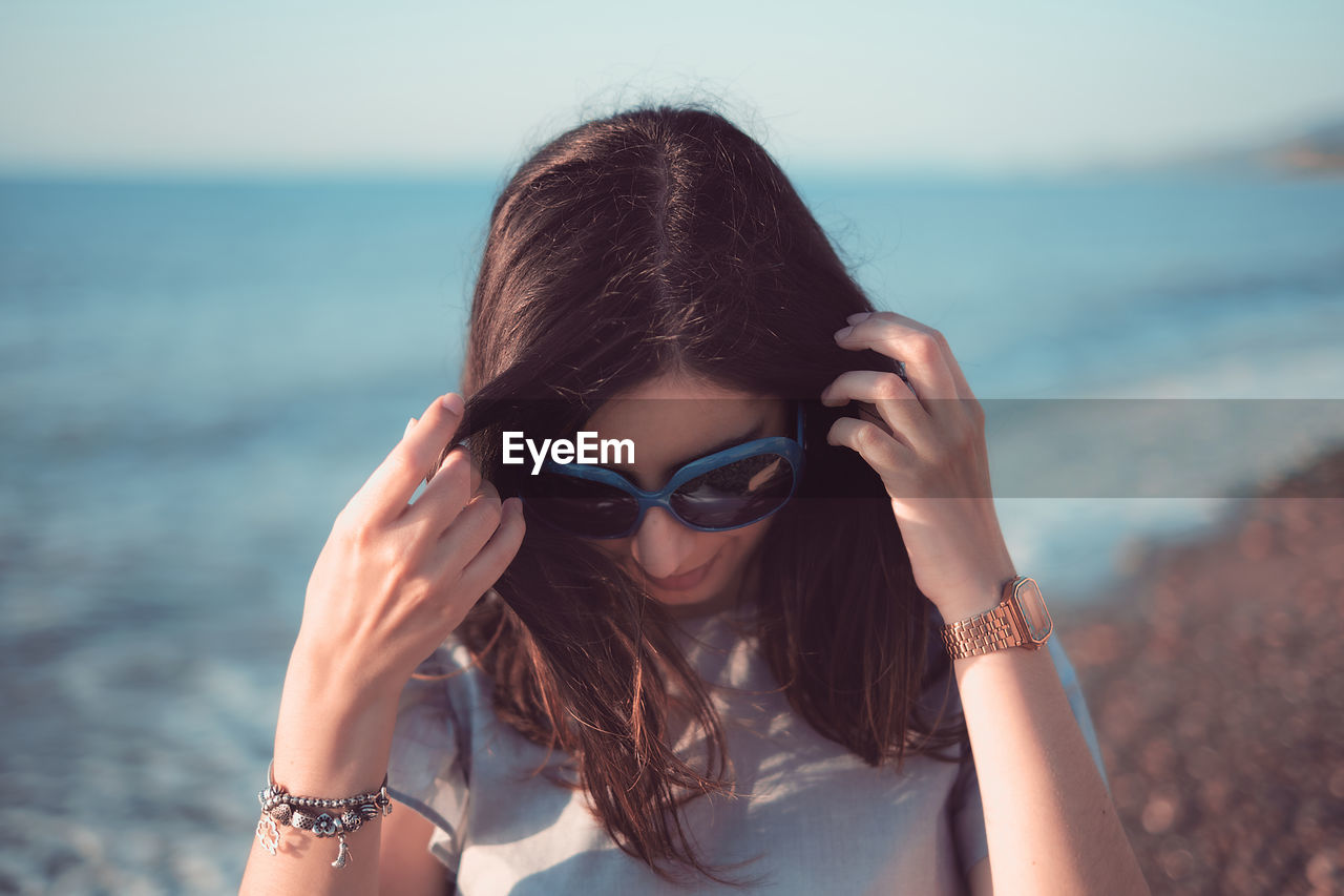 Portrait of young woman wearing sunglasses at beach