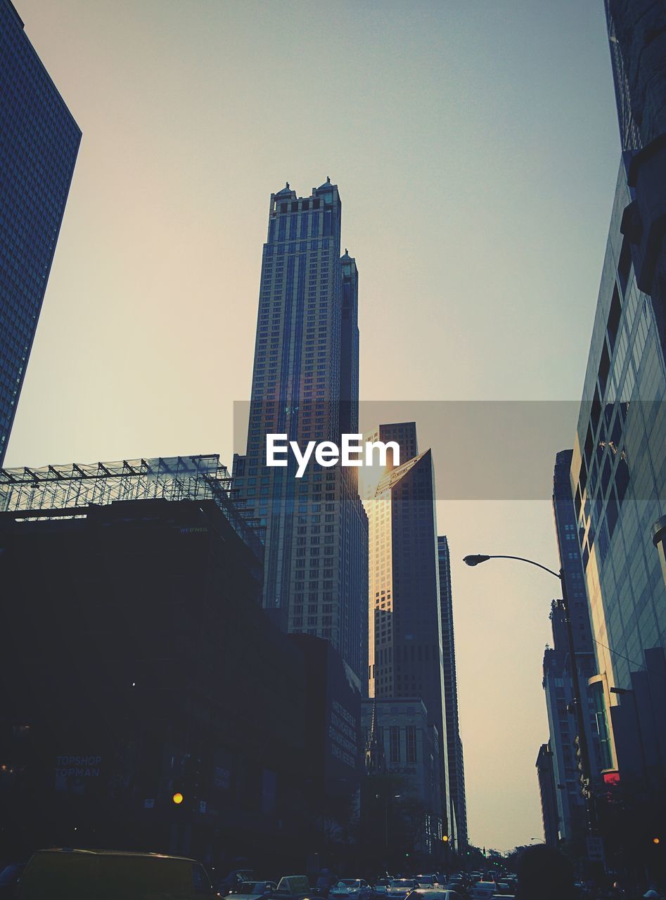 Low angle view of skyscrapers in city during sunset