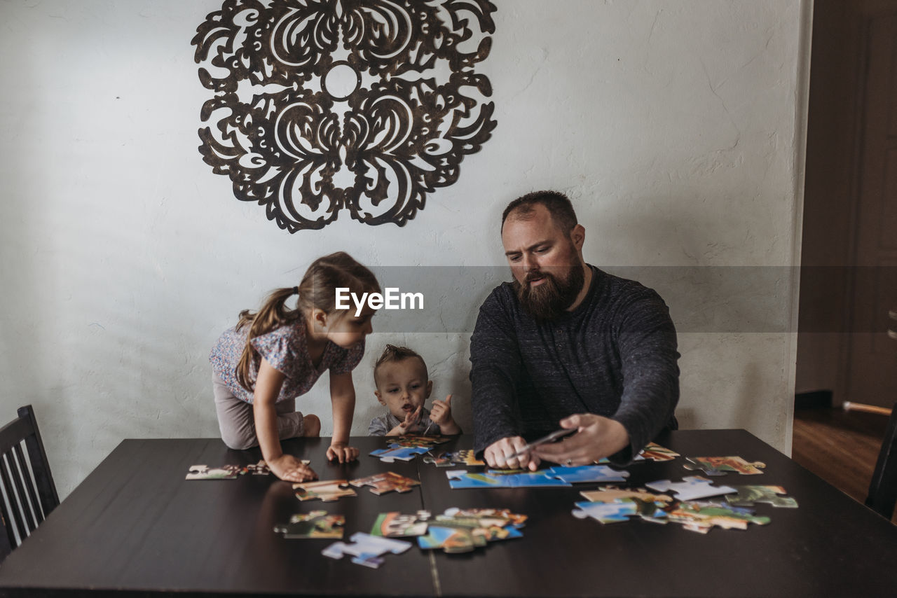 Family completing puzzle at home during isolation