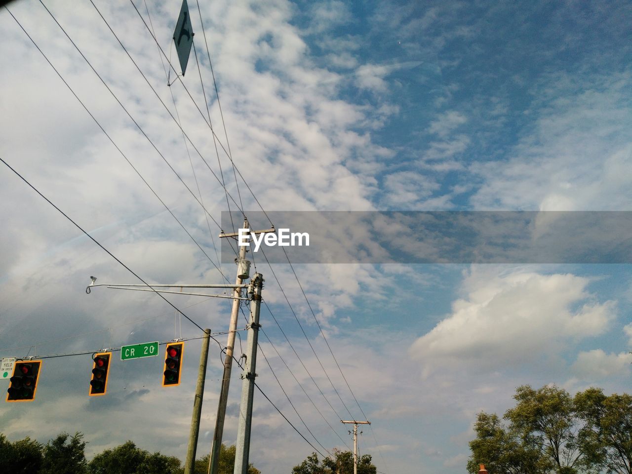 LOW ANGLE VIEW OF POWER LINE AGAINST CLOUDY SKY