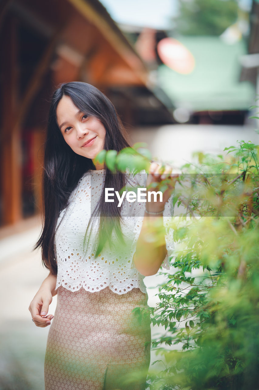 Portrait of young woman standing outdoors