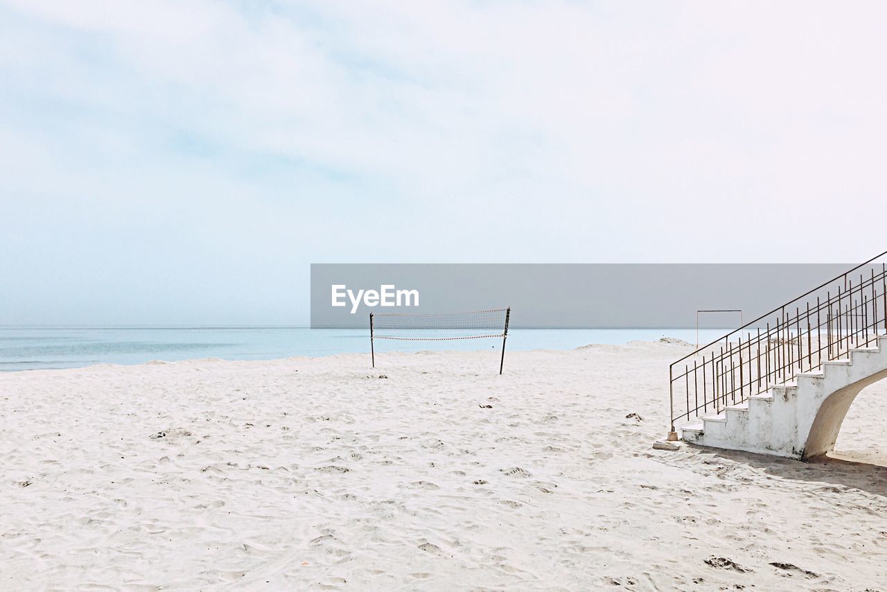 Scenic view of beach against cloudy sky