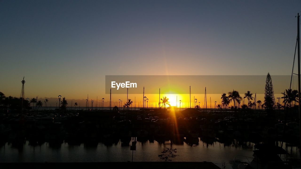 Silhouette of boats in lake during sunset