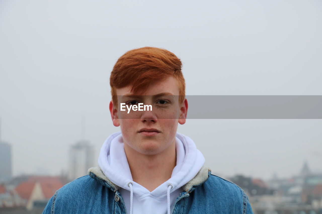 Portrait of teenage boy against sky