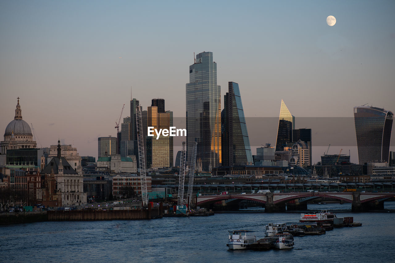 View of buildings at waterfront during sunset