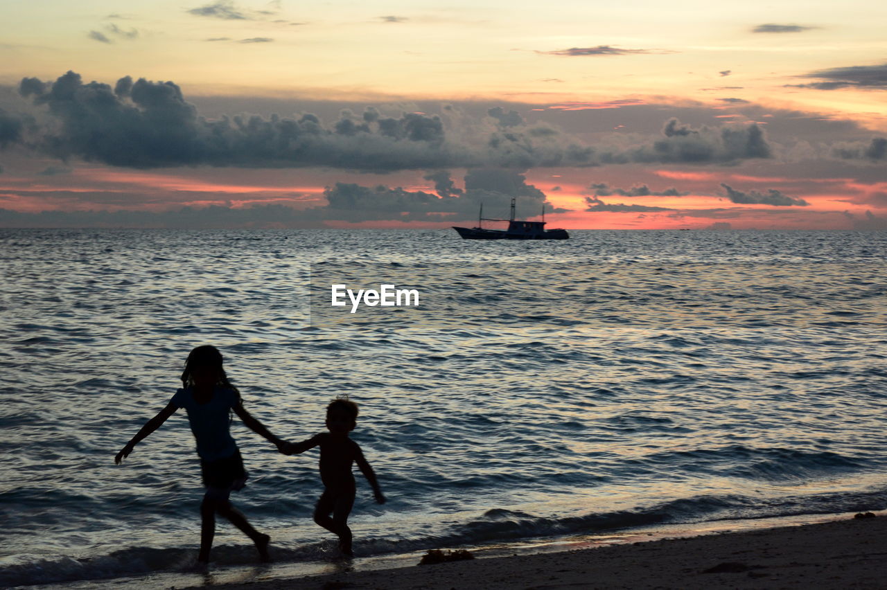 SILHOUETTE WOMEN ON SEA DURING SUNSET