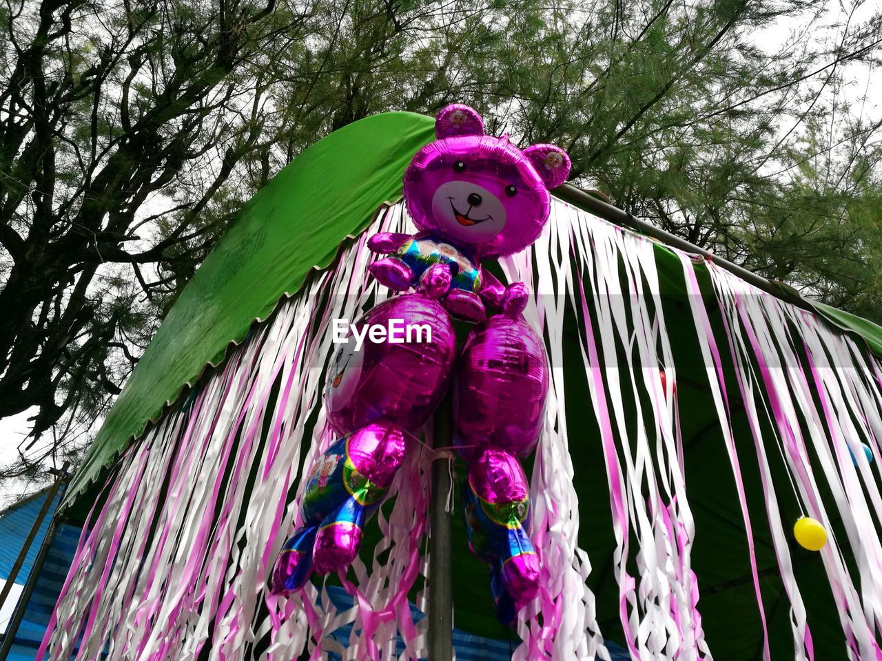 LOW ANGLE VIEW OF PINK STATUE AGAINST TREES