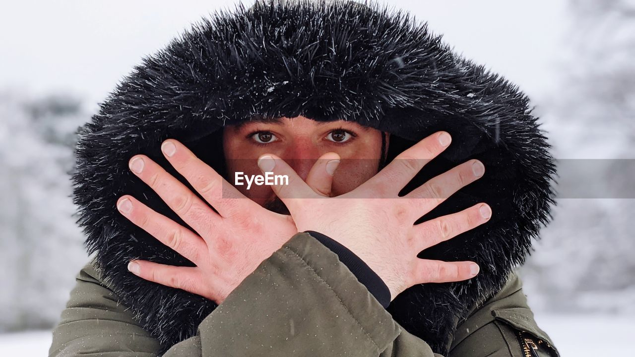 Portrait of man covering face with snow