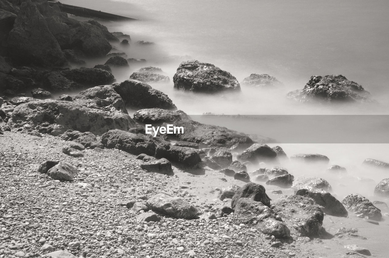 High angle view of rocks at beach during sunny day