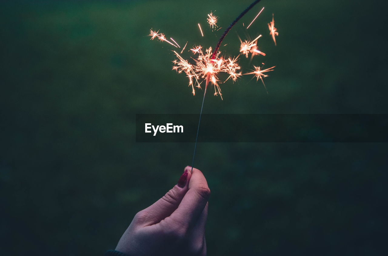 Close-up of hand holding illuminated sparkler