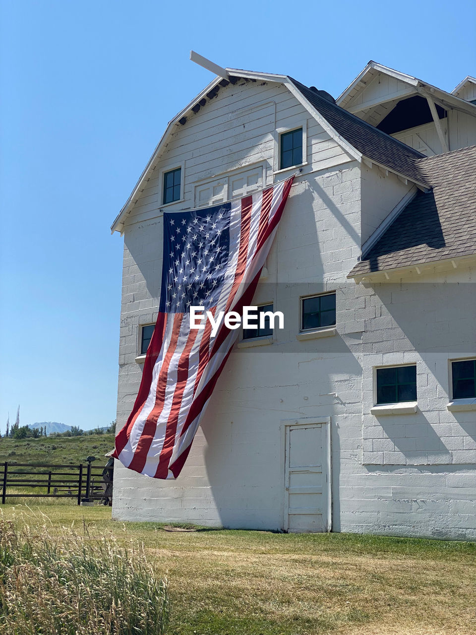 LOW ANGLE VIEW OF FLAGS ON FIELD AGAINST BUILDINGS