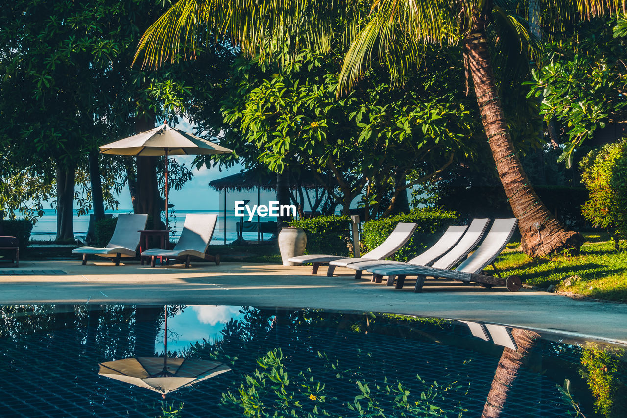 View of swimming pool and lounge chairs at tourist resort