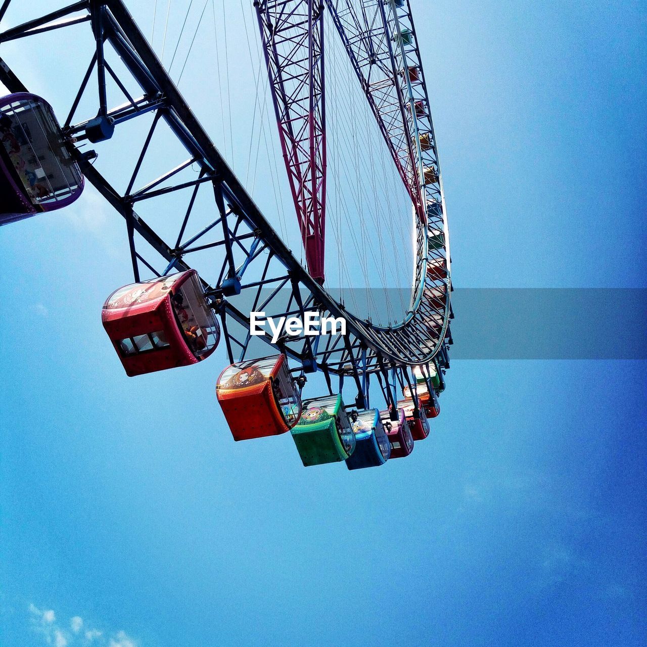 Low angle view of ferris wheel against blue sky