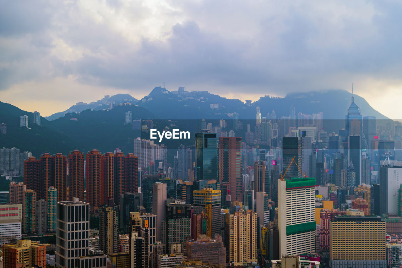 Aerial view of buildings in city against sky