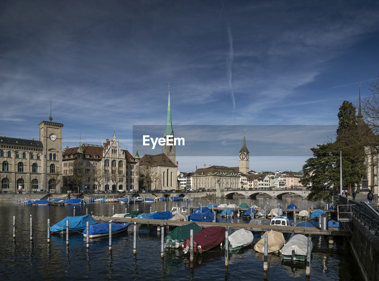 BOATS MOORED IN CANAL BY BUILDINGS IN CITY