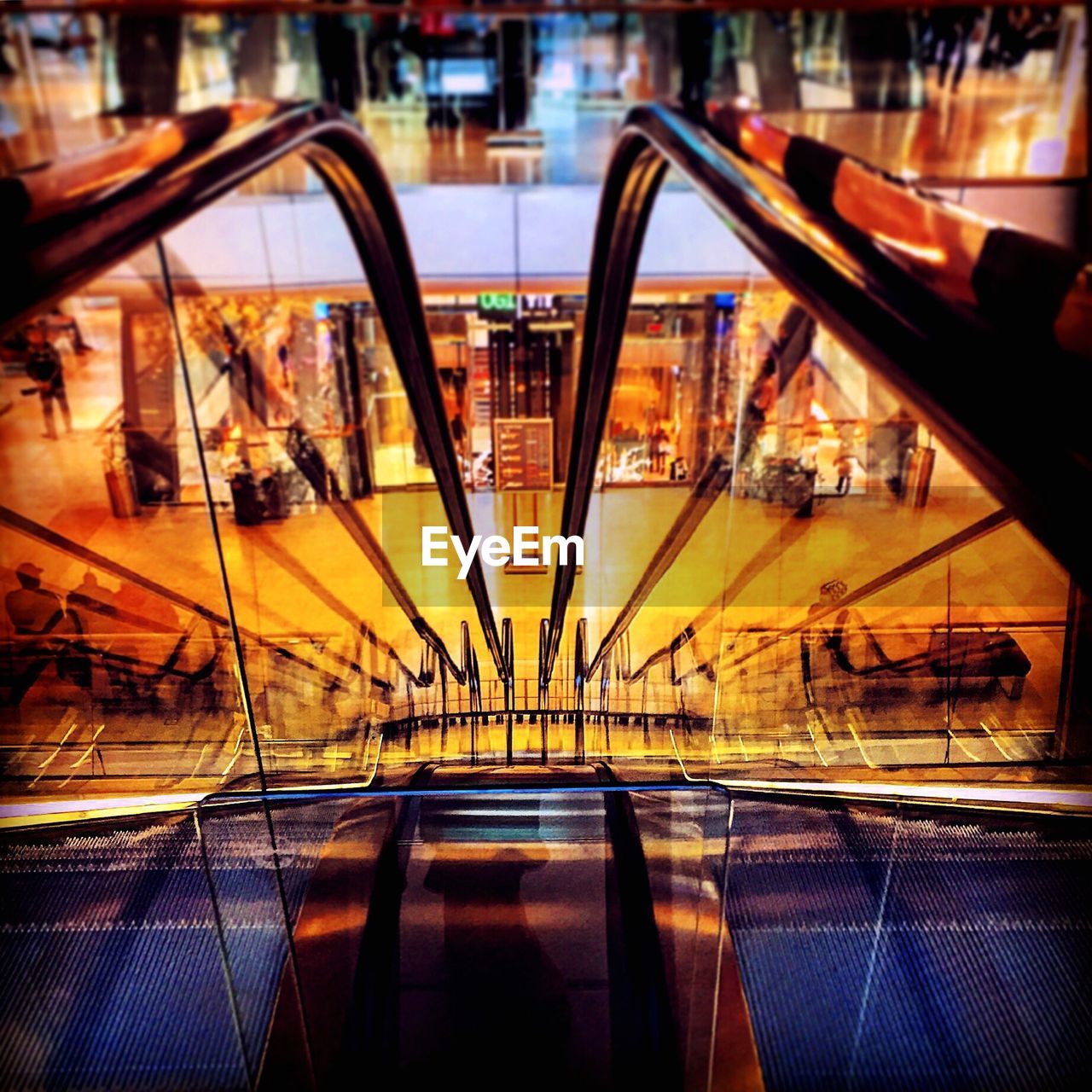 Reflection of illuminated city in mirror at a escalator 