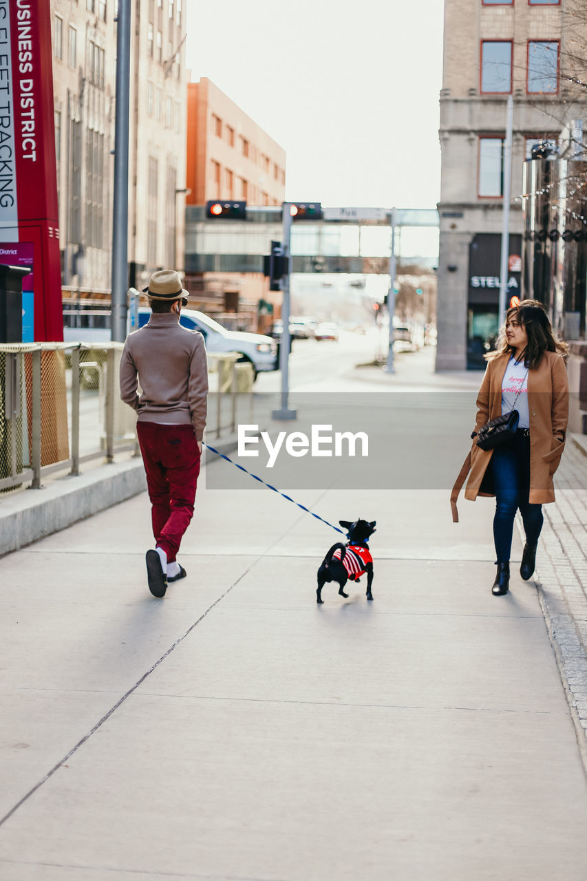 FULL LENGTH REAR VIEW OF PEOPLE WALKING ON STREET