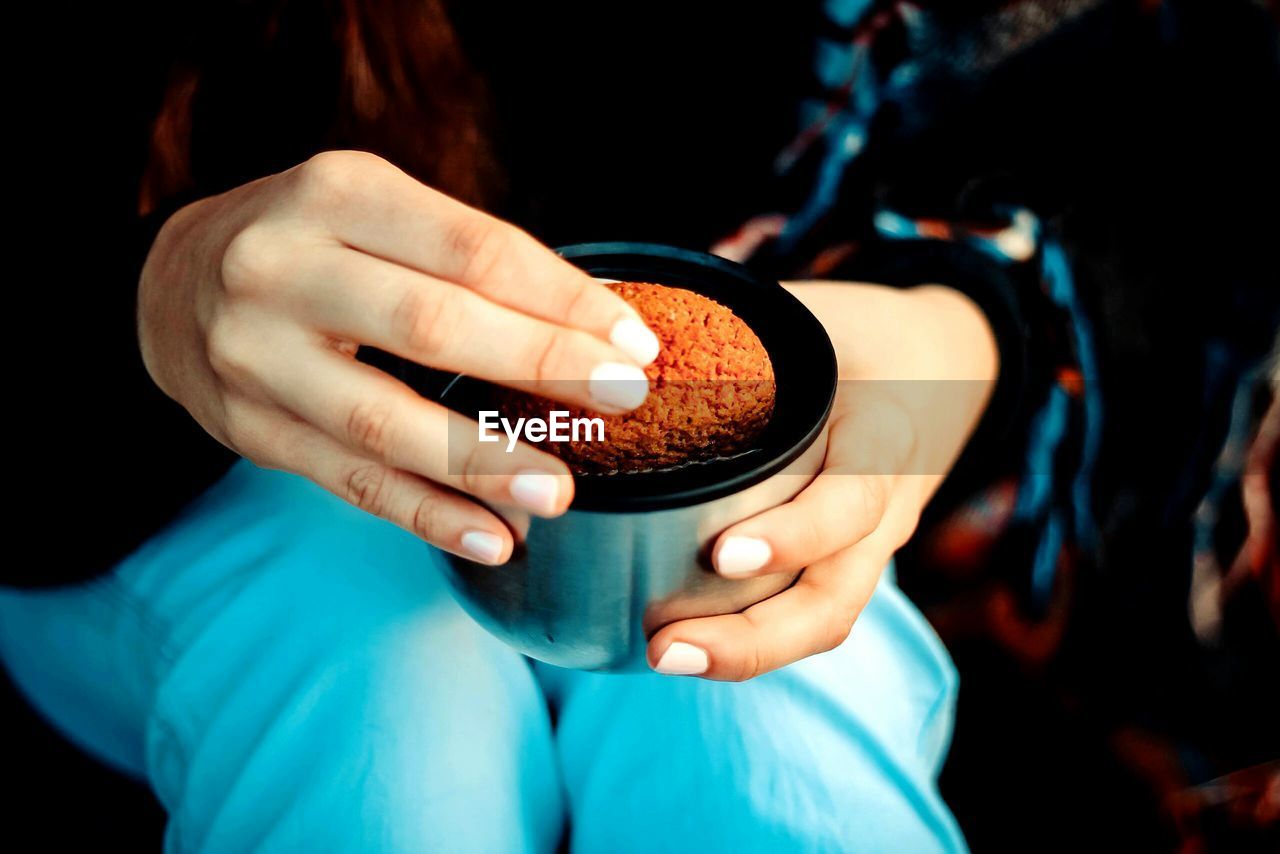 Midsection of woman having cookie