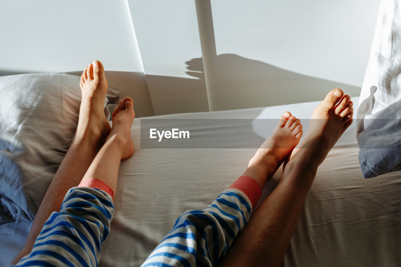 Elder child and smaller child feet in the parent's bed
