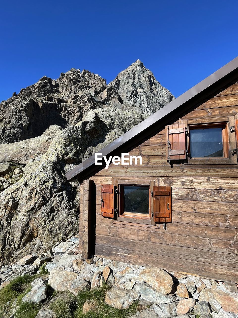 architecture, built structure, building exterior, wall, building, no people, nature, rock, day, window, house, blue, clear sky, outdoors, sky, low angle view, old, history, wall - building feature, wood, the past, sunlight, residential district