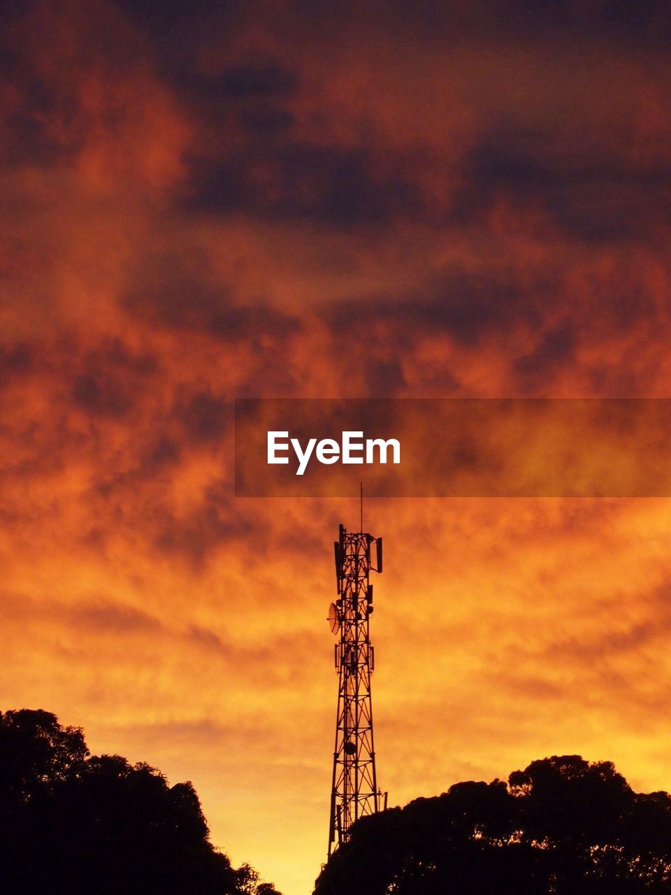 Low angle view of silhouette communication tower against sky during sunset