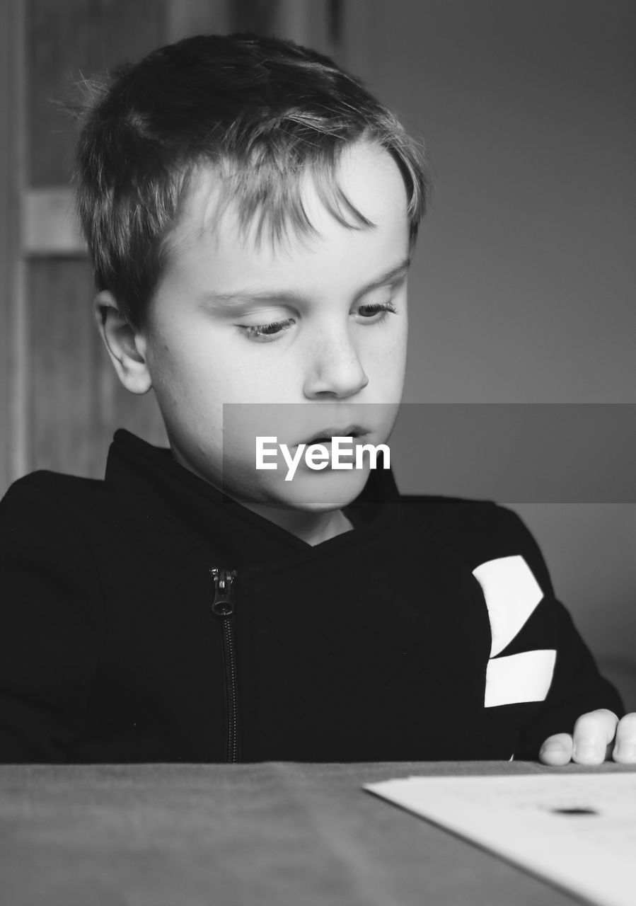 Portrait of cute boy looking away at home