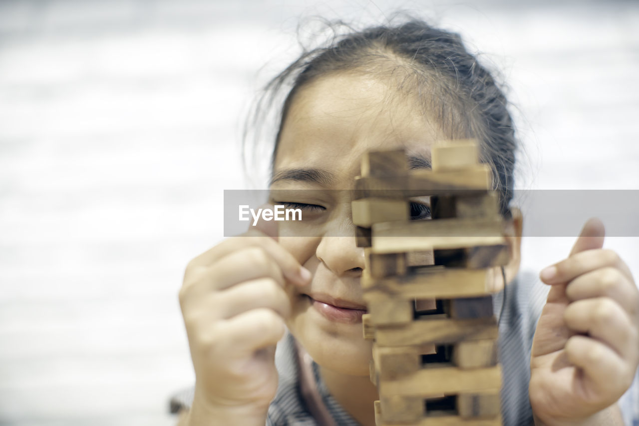 Close-up of girl playing black removal game at home