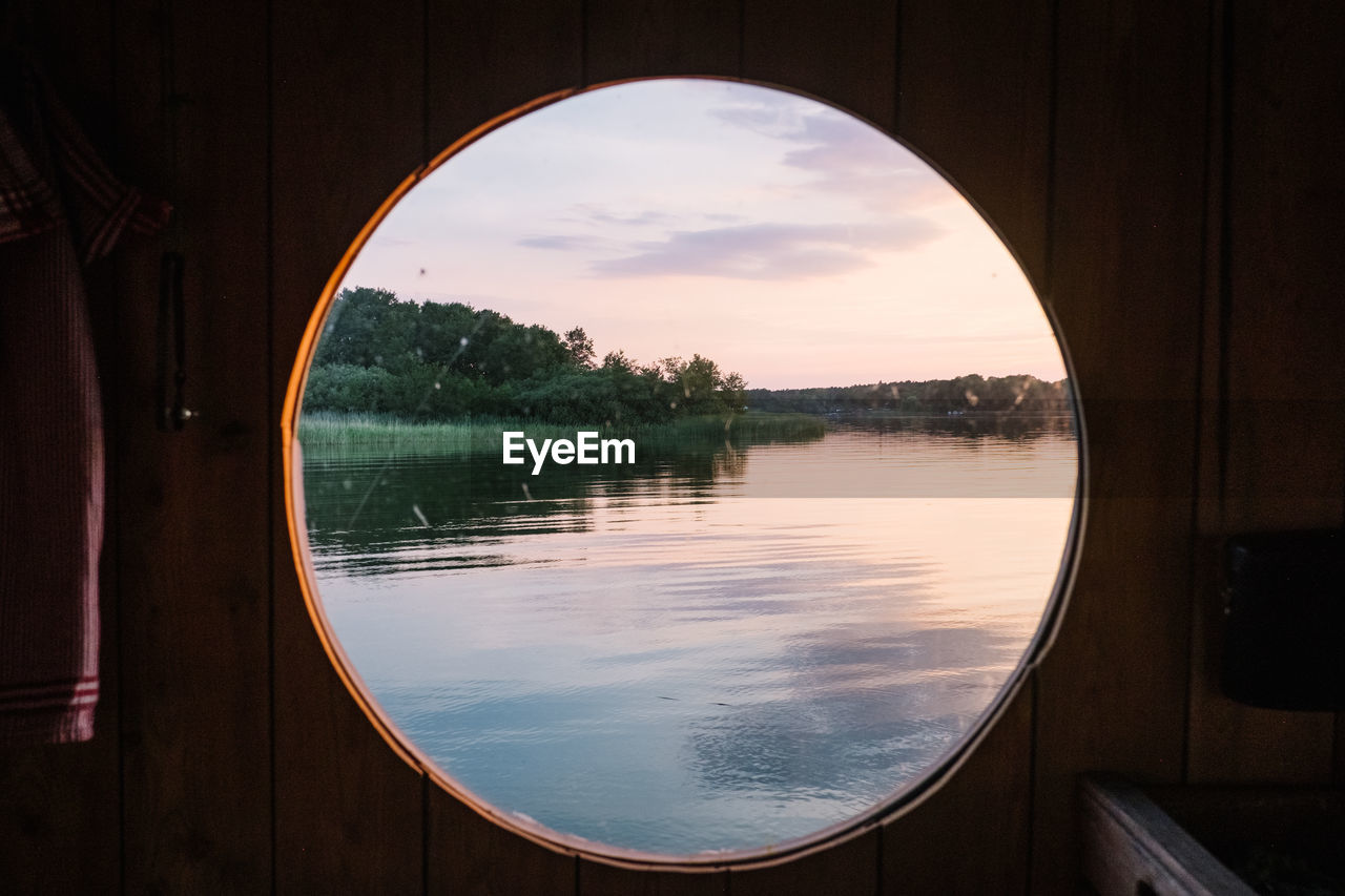 Scenic view of lake against sky seen through window