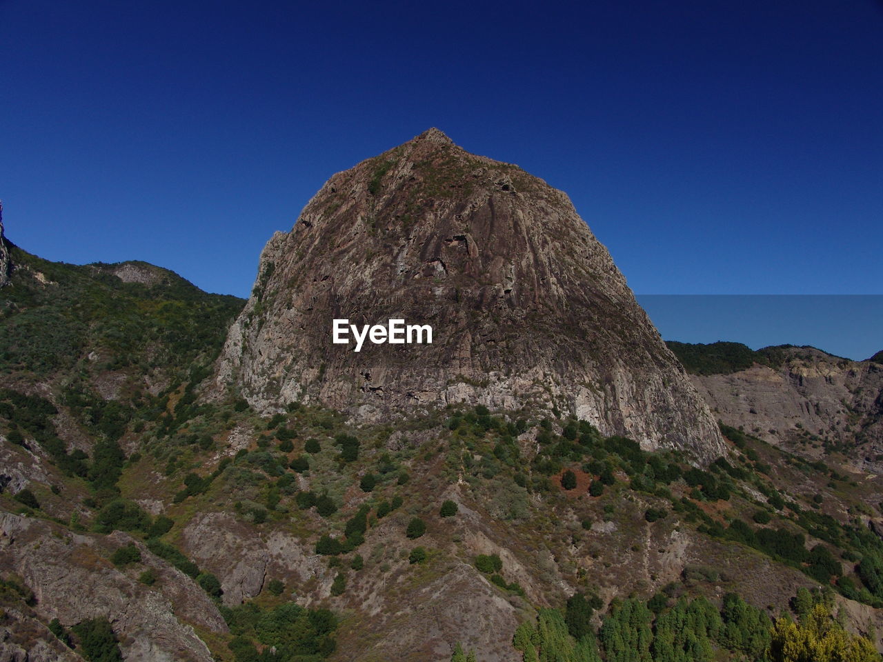 Low angle view of rock formations against clear blue sky