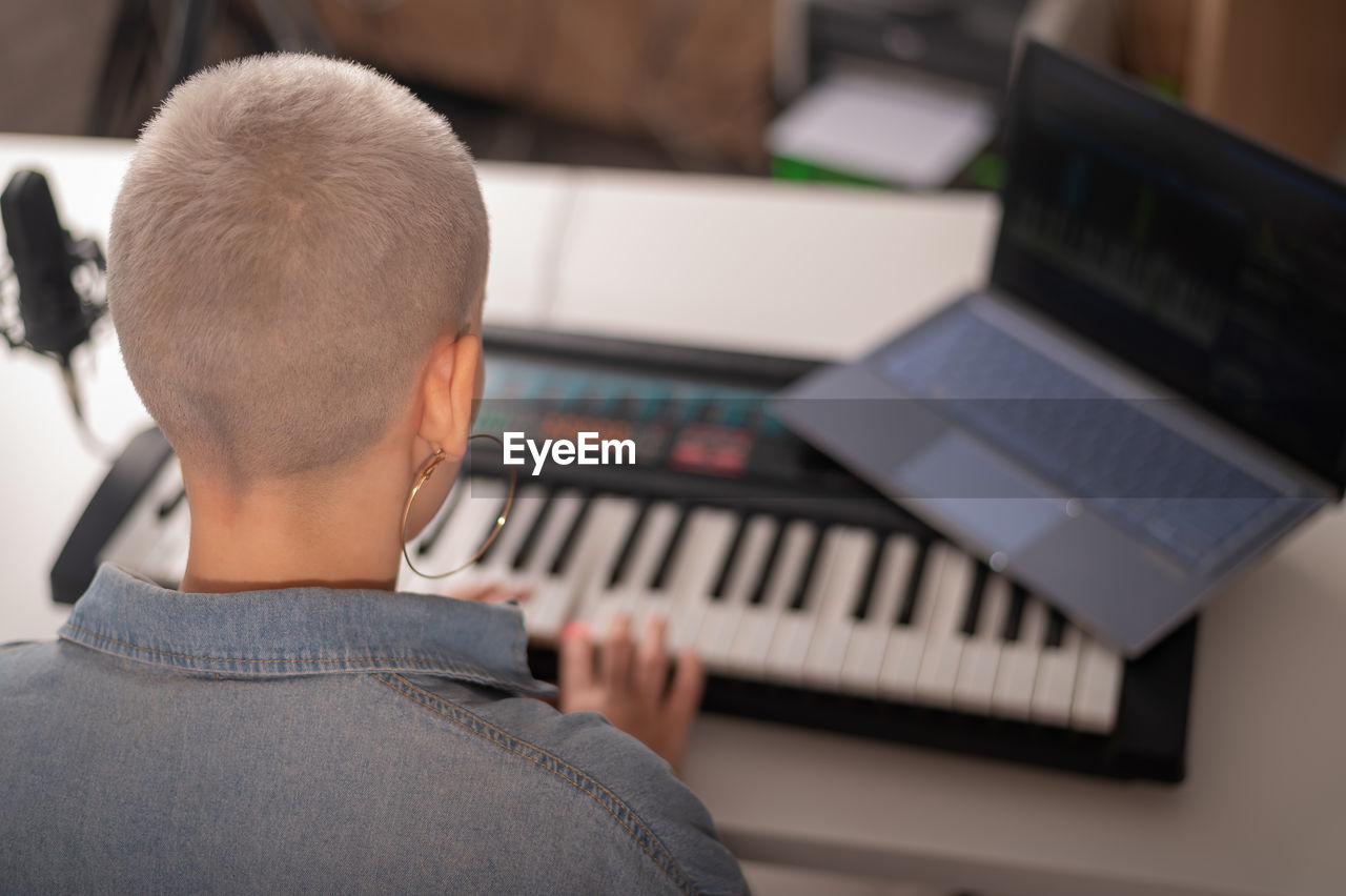 Rear view of woman playing piano