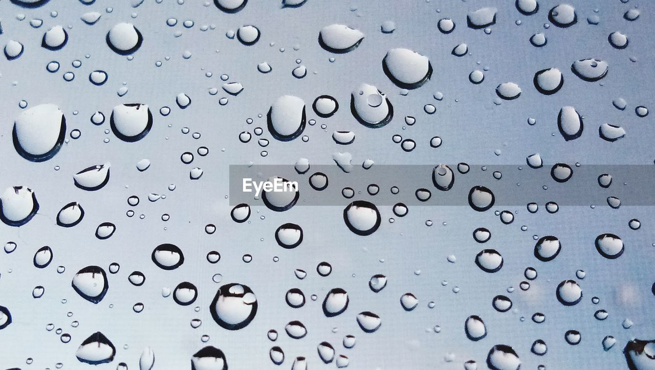 FULL FRAME SHOT OF RAINDROPS ON WINDOW