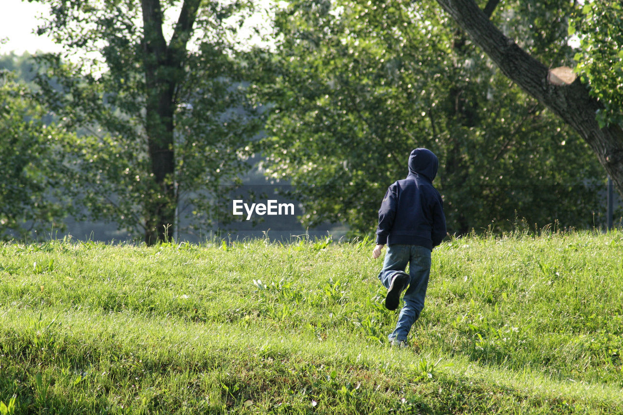 Rear view of boy running on field