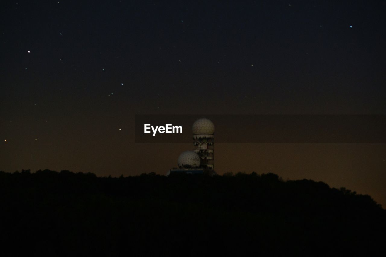 Low angle view of teufelsberg against star field at night