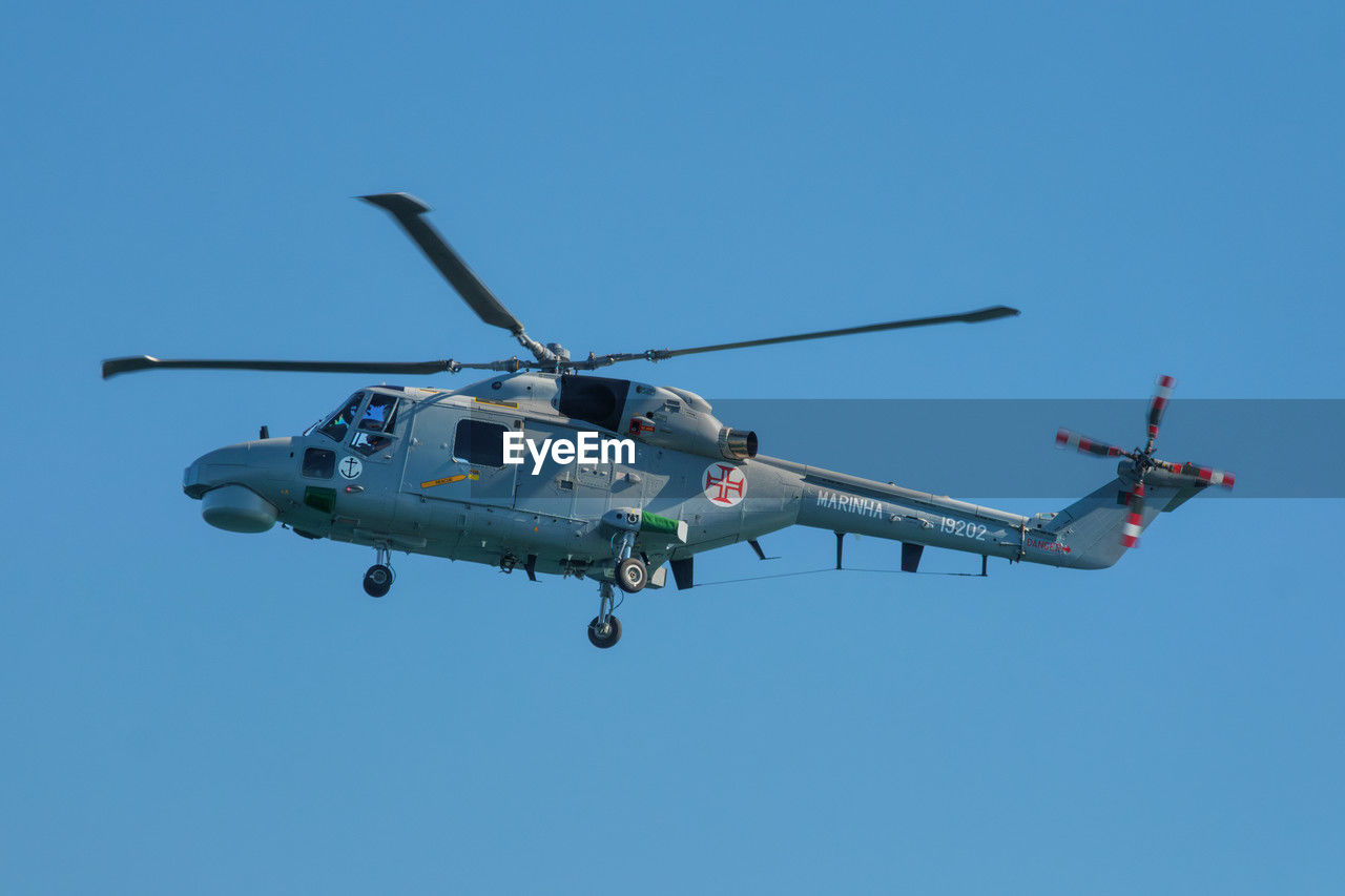 helicopter, air vehicle, transportation, mode of transportation, flying, vehicle, helicopter rotor, sky, military, rotorcraft, airplane, blue, clear sky, military helicopter, aircraft, motion, mid-air, on the move, army, aviation, nature, propeller, sunny, single object, aerospace industry, armed forces, air force, no people, day, hovering, outdoors