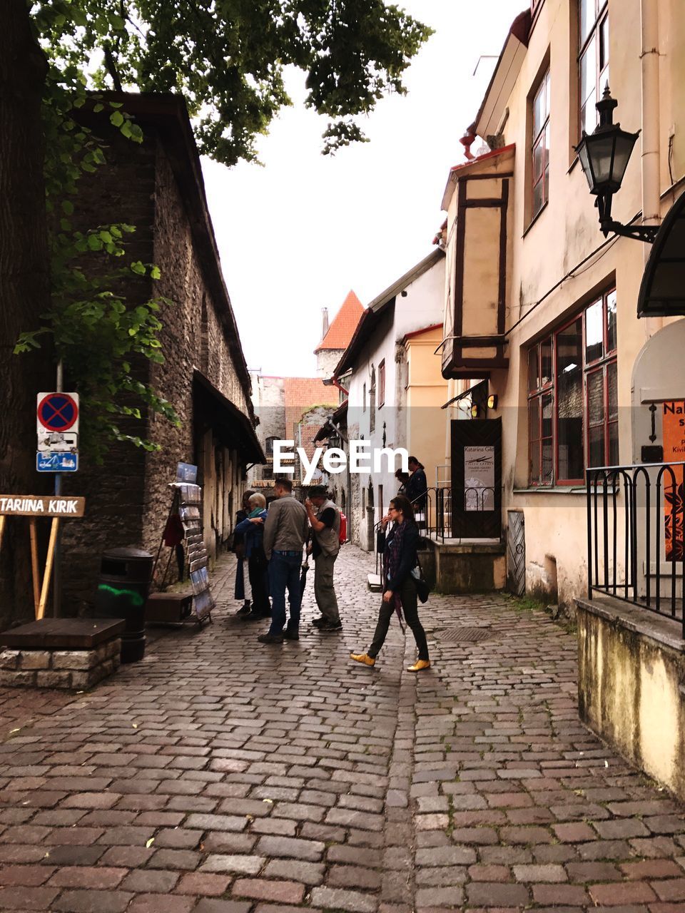 PEOPLE WALKING IN CITY AGAINST SKY